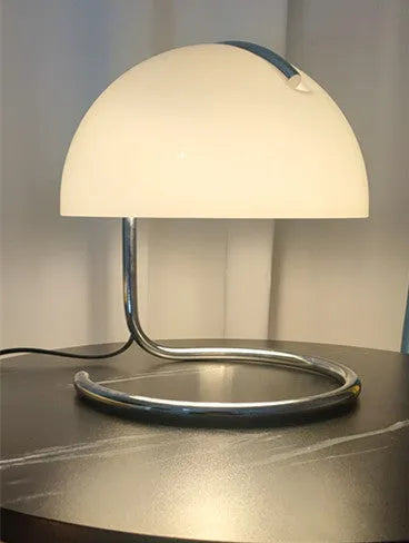 Retro metal mushroom table lamp with three-colour light in orange finish on a bedside table