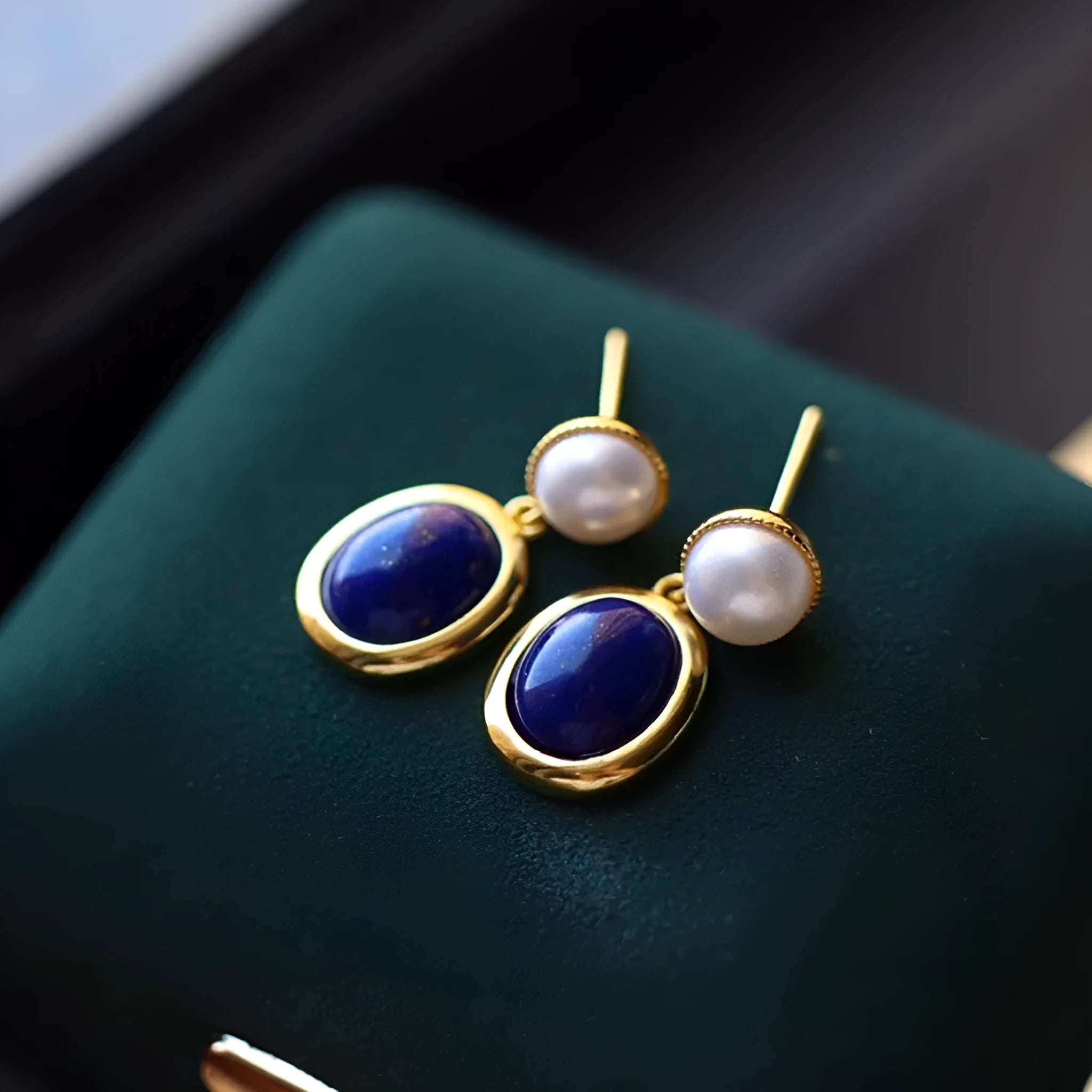 A pair of silver earrings with blue lapis lazuli pearls and auspicious patterns.
