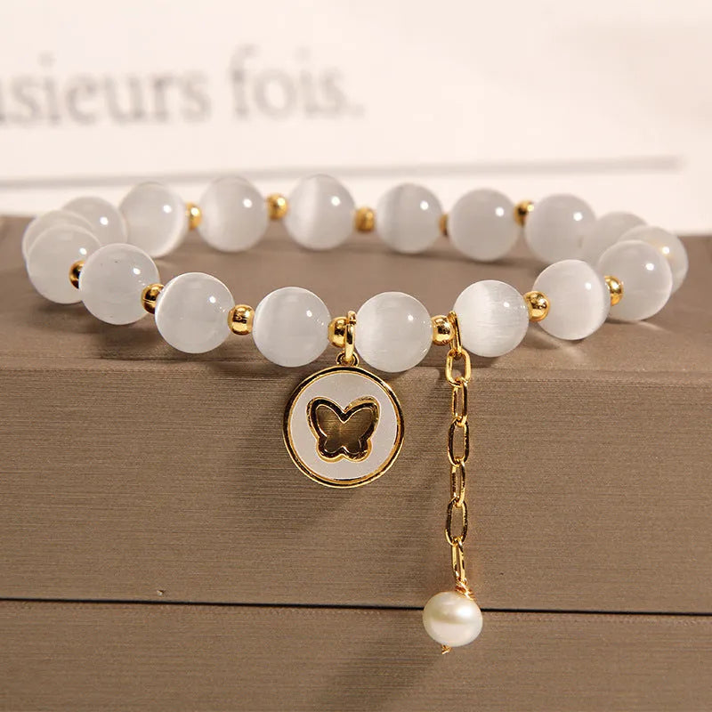 White geometric Cat's Eye crystal bracelet on a wrist, showing its handcrafted Korean-style design.
