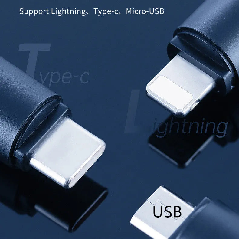Small black capsule infrared emitter remote control for smartphones next to a phone.