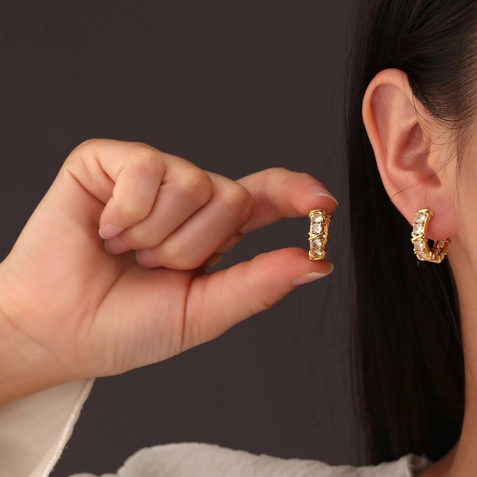 A pair of geometric copper earrings featuring a hexagonal shape with a clover cross design, shown in silver and gold colour options.