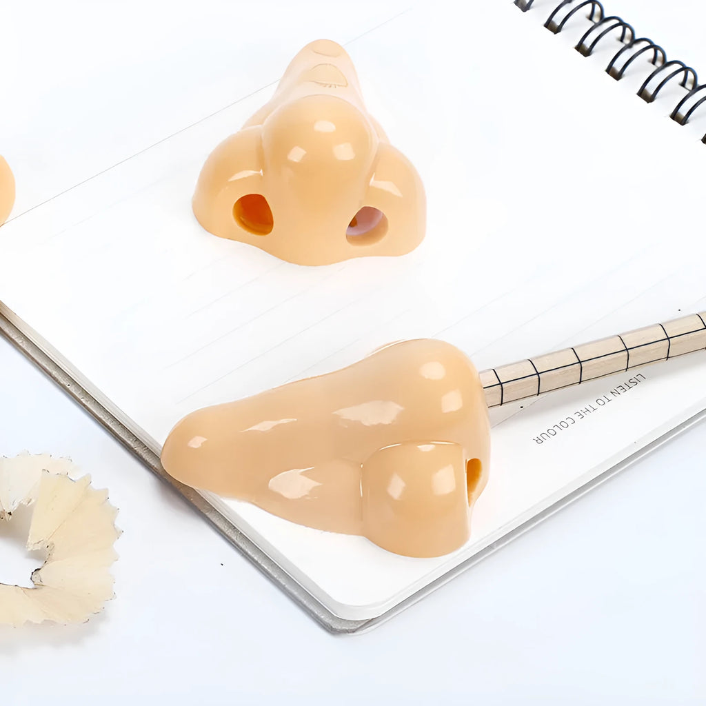 Flesh-coloured plastic student pencil sharpener with geometry design on a white background.