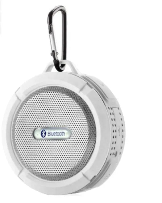 White waterproof Bluetooth speaker with a large clear suction cup mounted on a tiled wall.