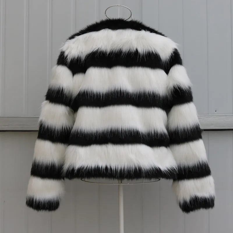 Womens black and white striped faux fur leather jacket with long sleeves on a model.