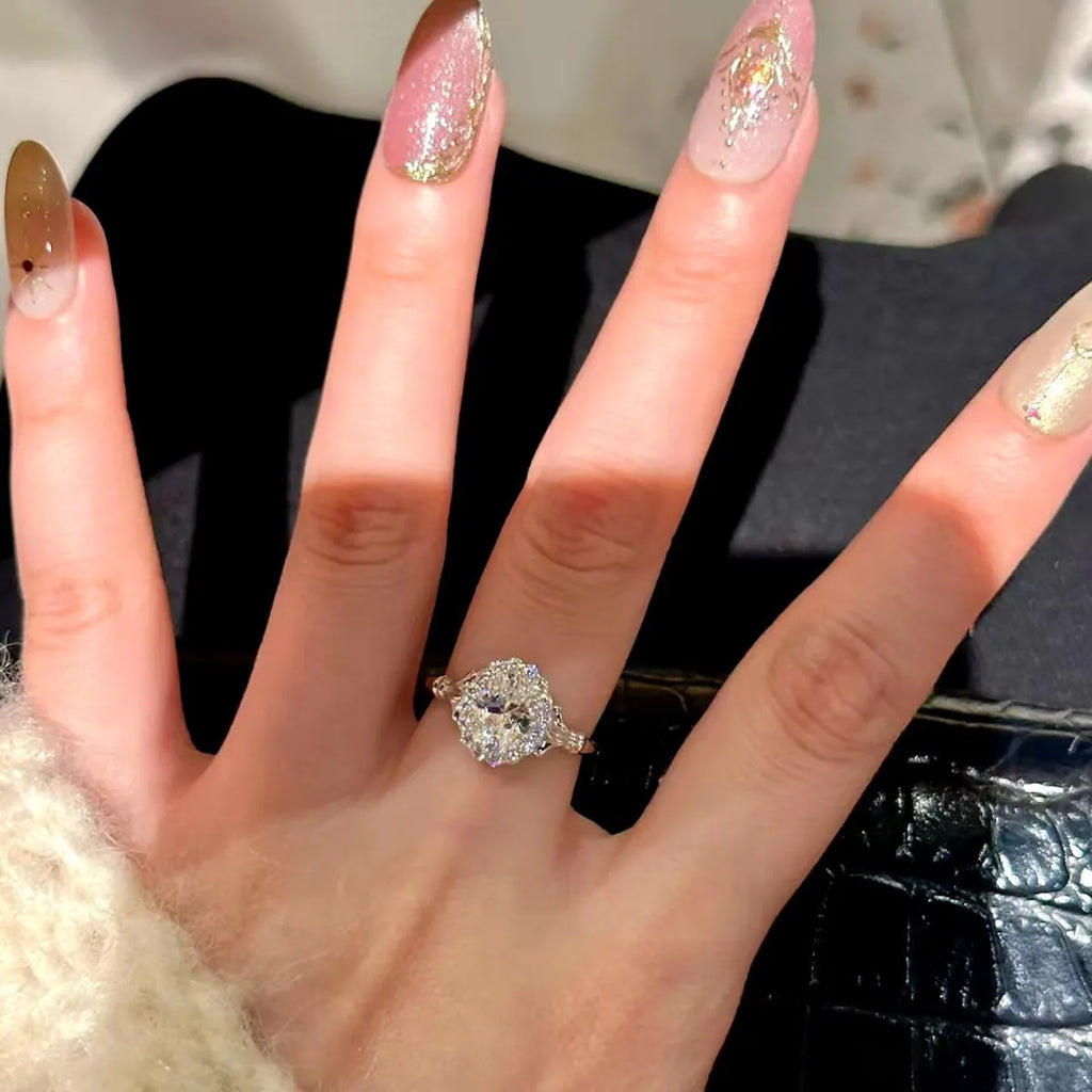 Close-up of a silver women's ring with an adjustable geometric band and a large oval bridal bouquet style diamond cluster.