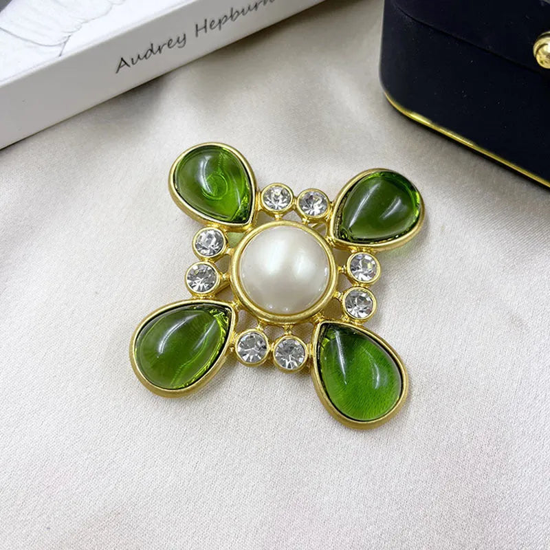 Close-up of a vintage medieval baroque style zinc alloy brooch with a crystal cross centrepiece.