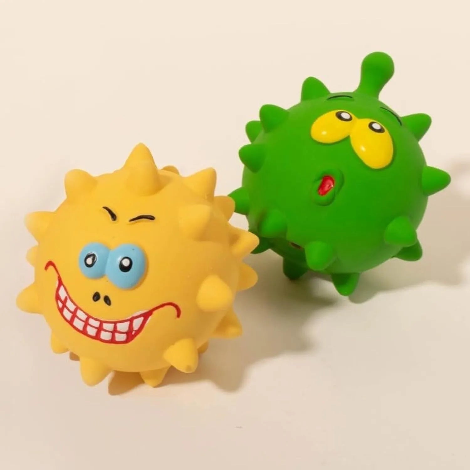 Set of four colourful latex squeaky dog balls with cute faces, each measuring 7.5cm.