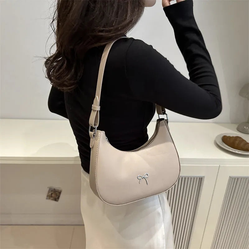 Women's underarm small shoulder bag in dumpling shape, shown in one of six colours: white, black, pink, khaki, brown, or silver.
