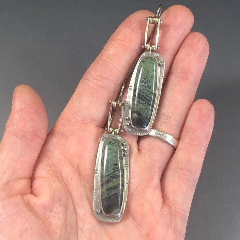 Geometric alloy earrings with a two-colour marble pattern on a white background.