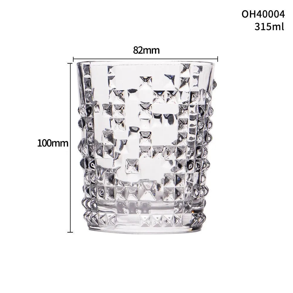 Clear crystal whiskey shot glass with thick bottom base on a table.