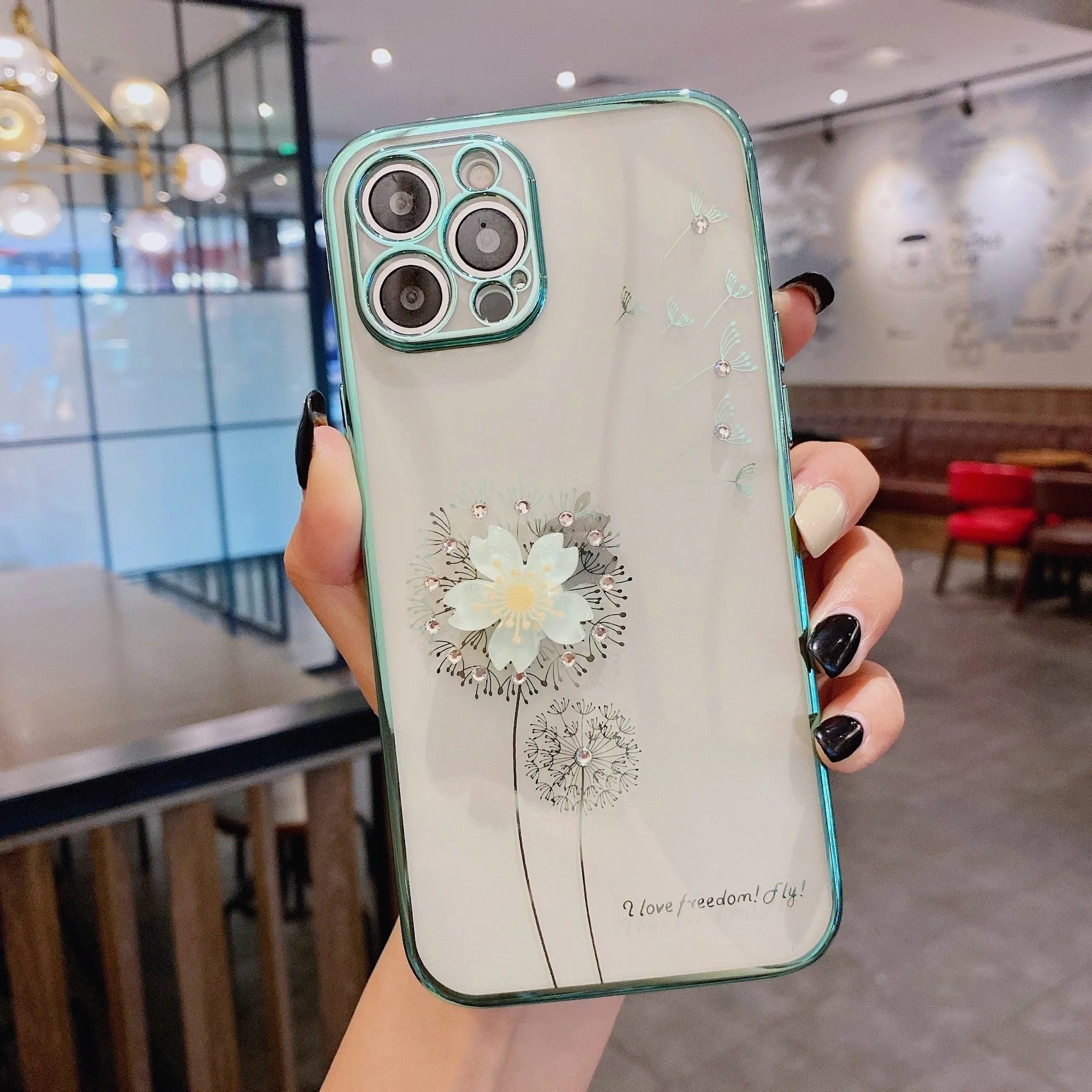 Green iPhone case with a built-in 3D white flower stand popped out, showing the phone propped up for viewing.