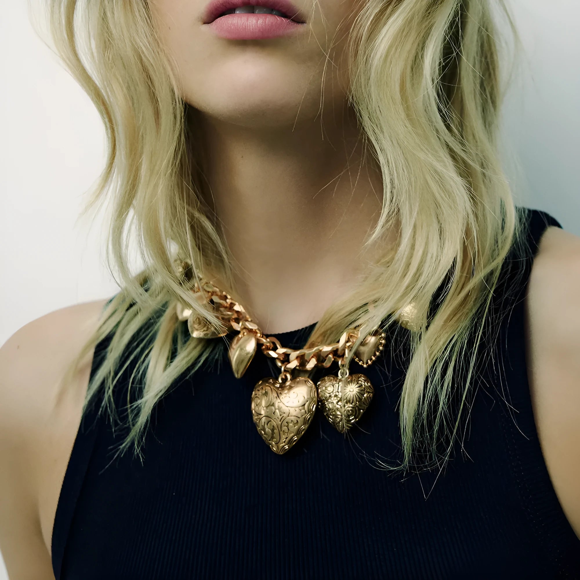 Gold women's necklace with a large, exaggerated heart-shaped pendant on an adjustable chain.