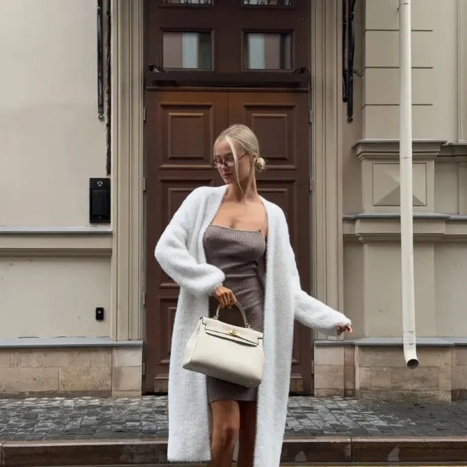 White long sleeve knitted cardigan jacket with a loose fit and extended length.