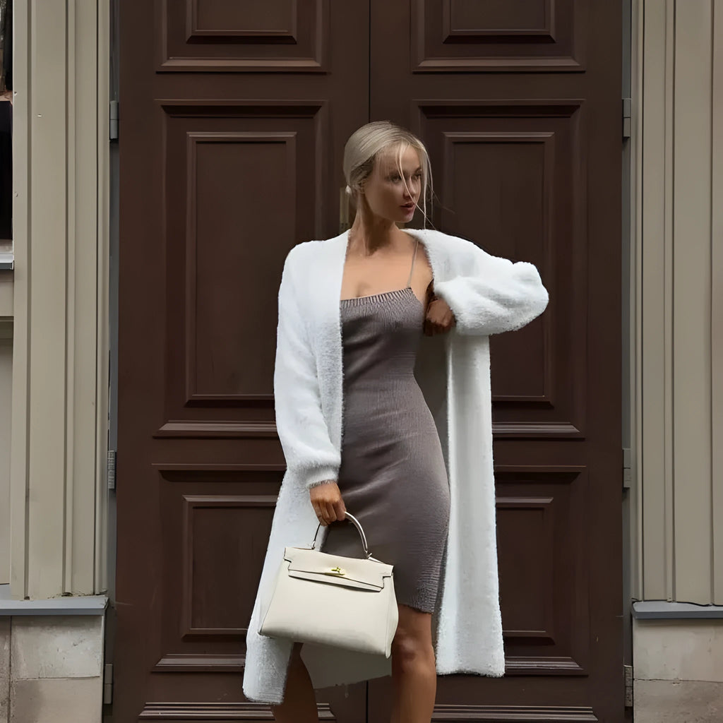 White long sleeve knitted cardigan jacket with a loose fit and extended length.
