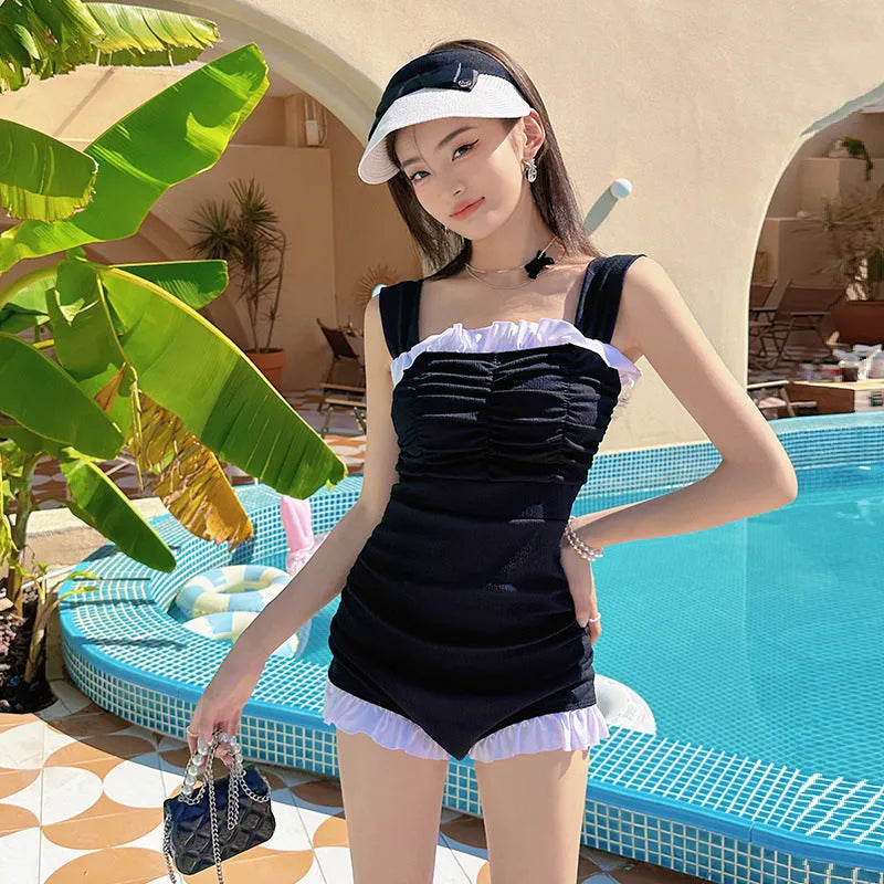Women's solid colour one-piece swimsuit with suspender straps in pink, green, or black options