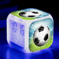Square cartoon football pattern children's alarm clock with mute alarm on a bedside table.