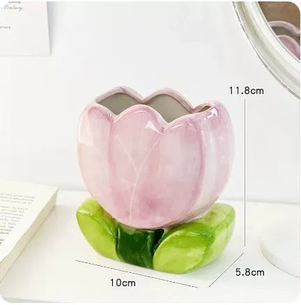 Ceramic floral pen holder box in pink tulip design on a desk.