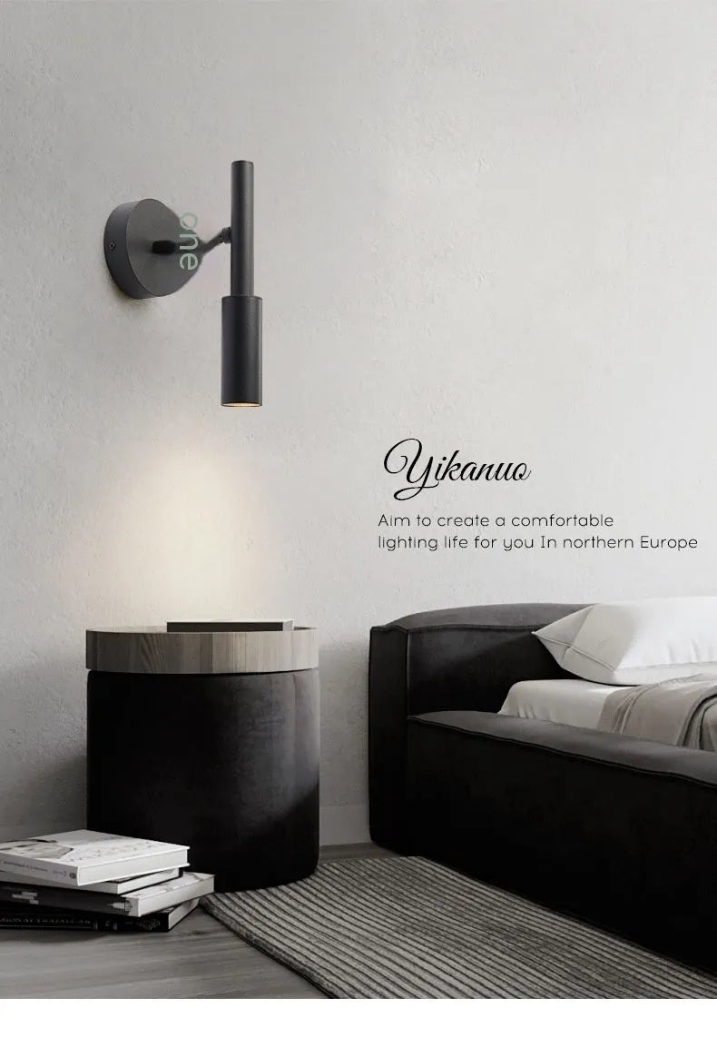 Black and white modern wrought iron wall lamp with a compact shade.