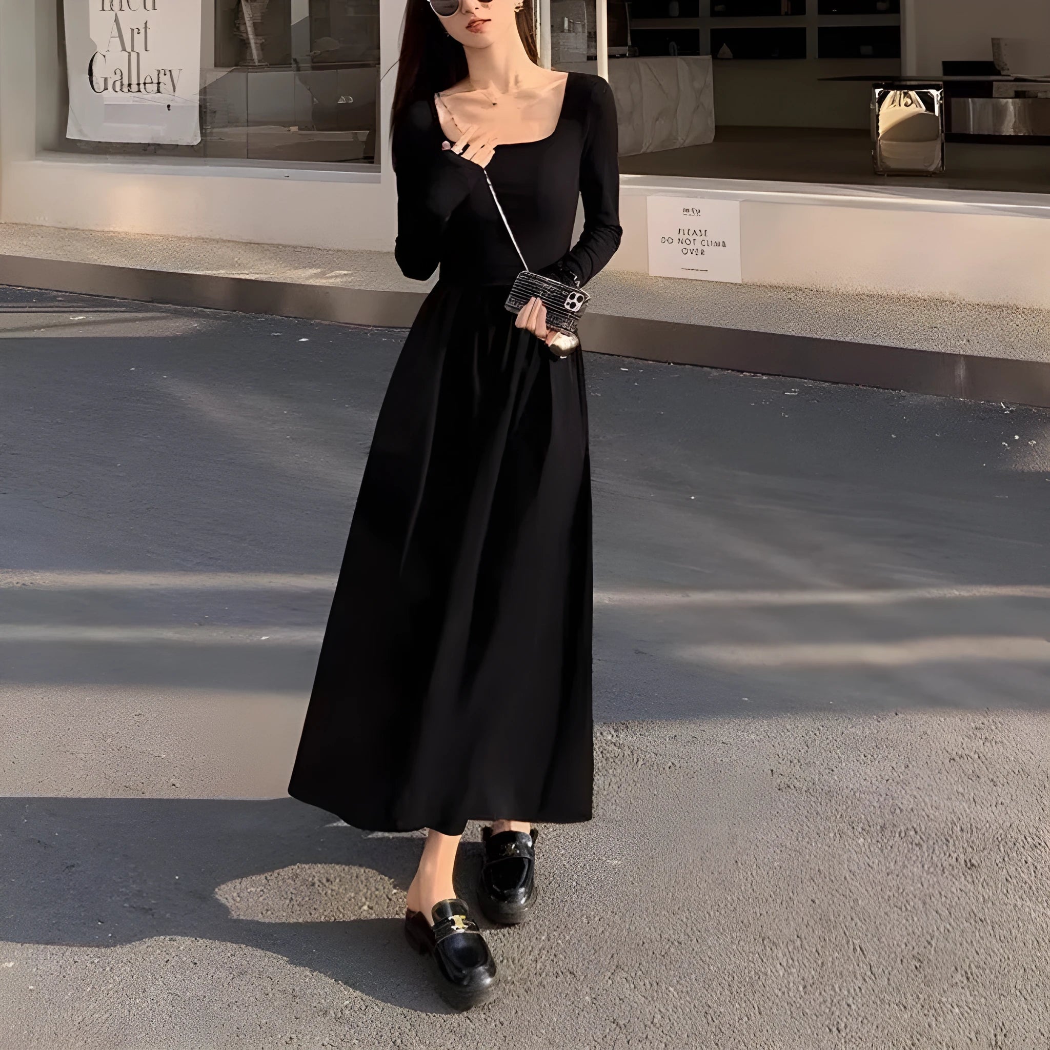 Women's black knitted dress with square collar, long sleeves, and an elastic A-line skirt.