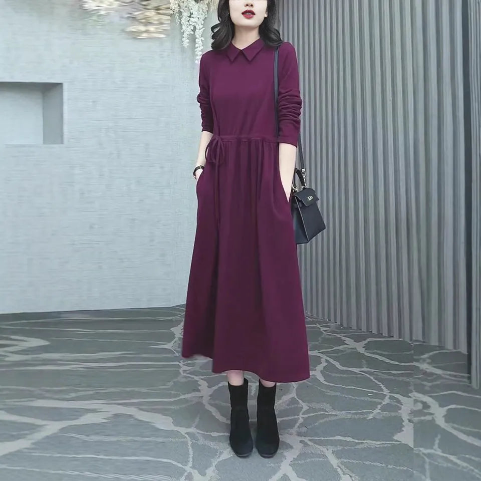 Purplish red women's long sleeve knee-length dress on a hanger, urban commute style.