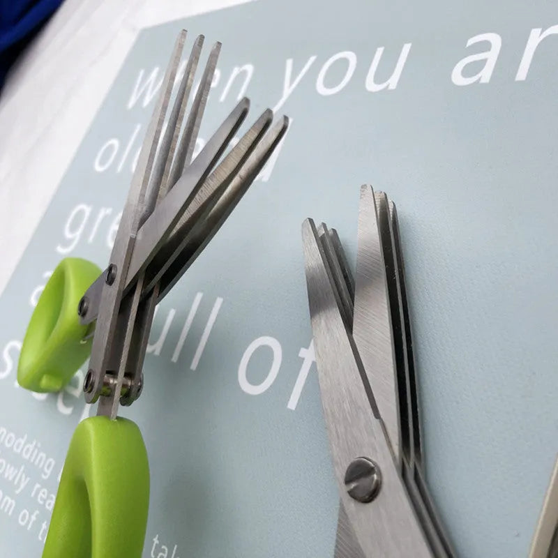 Stainless steel multi-layer kitchen scissors for cutting green onions and herbs on a chopping board.