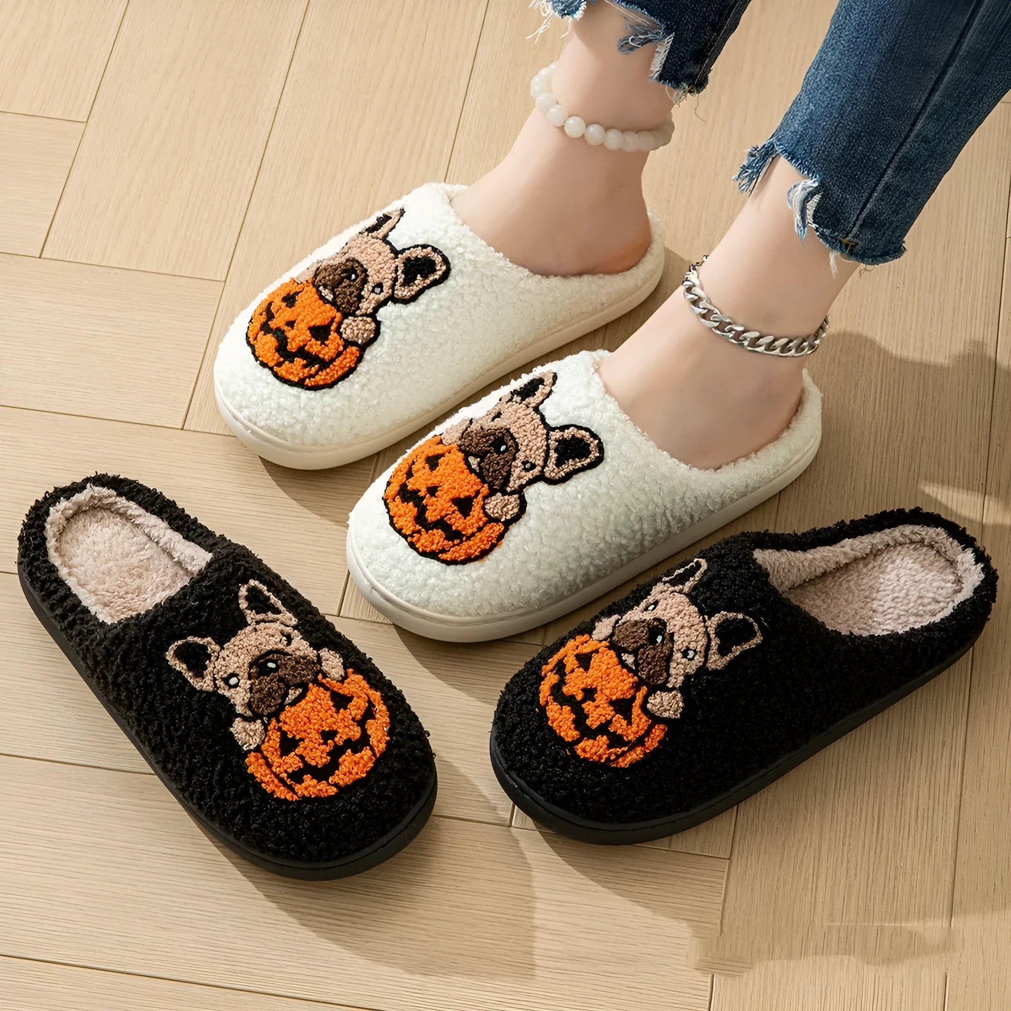 Black and white plush Halloween slippers with pumpkin pattern, round toe, and textured TPR sole.