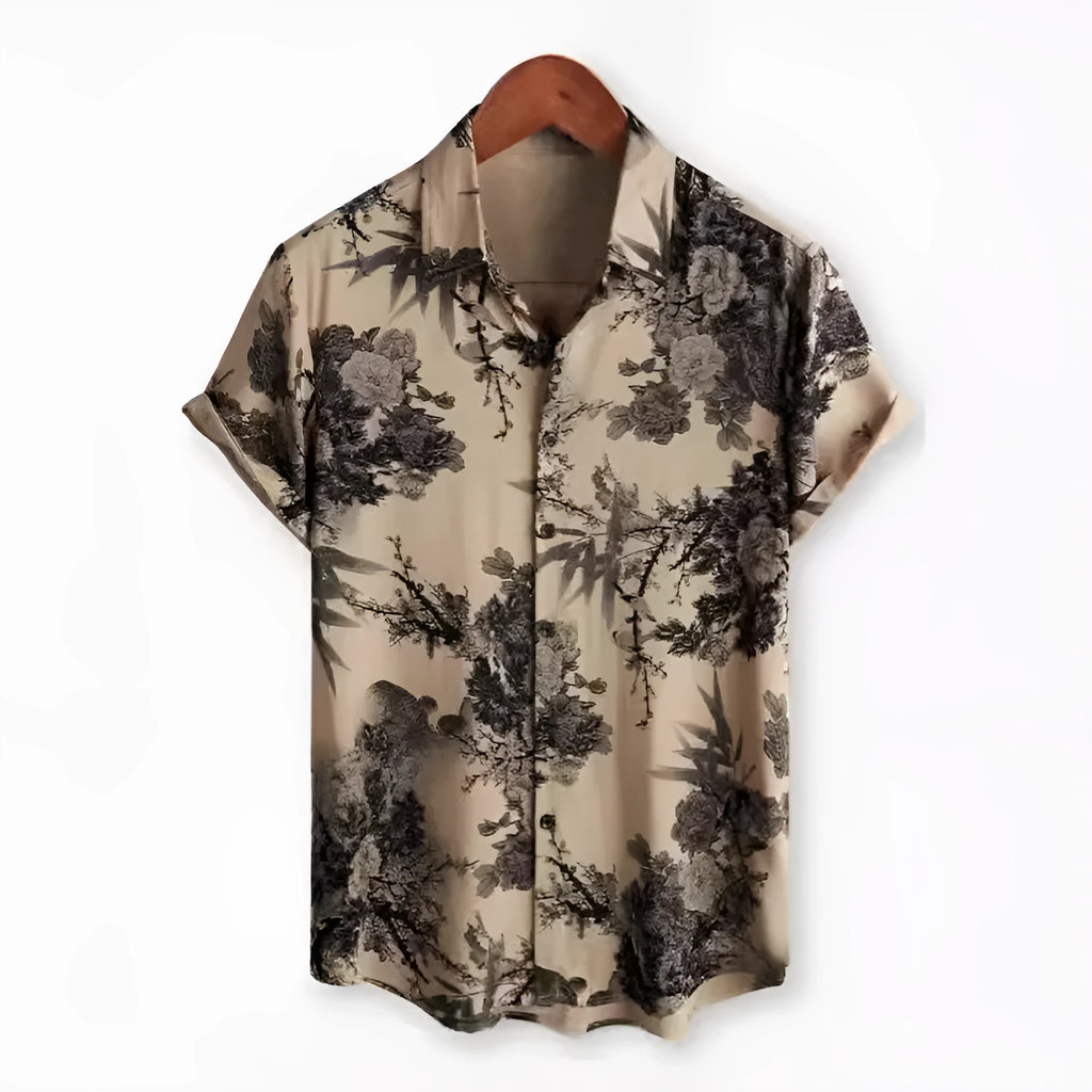 A man wearing a short sleeve floral print Hawaiian shirt with a button-up front and lapel collar.