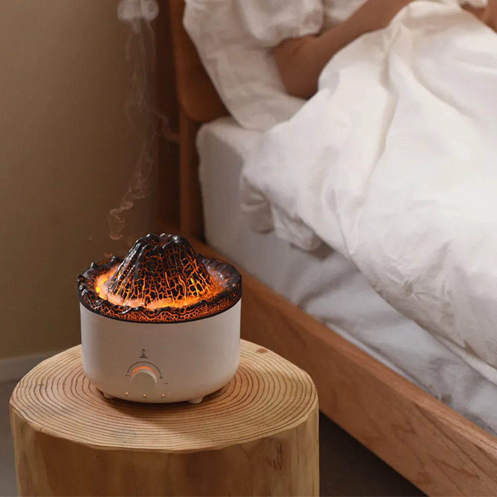 White simulated flame volcano humidifier and aroma diffuser with remote control on wooden surface