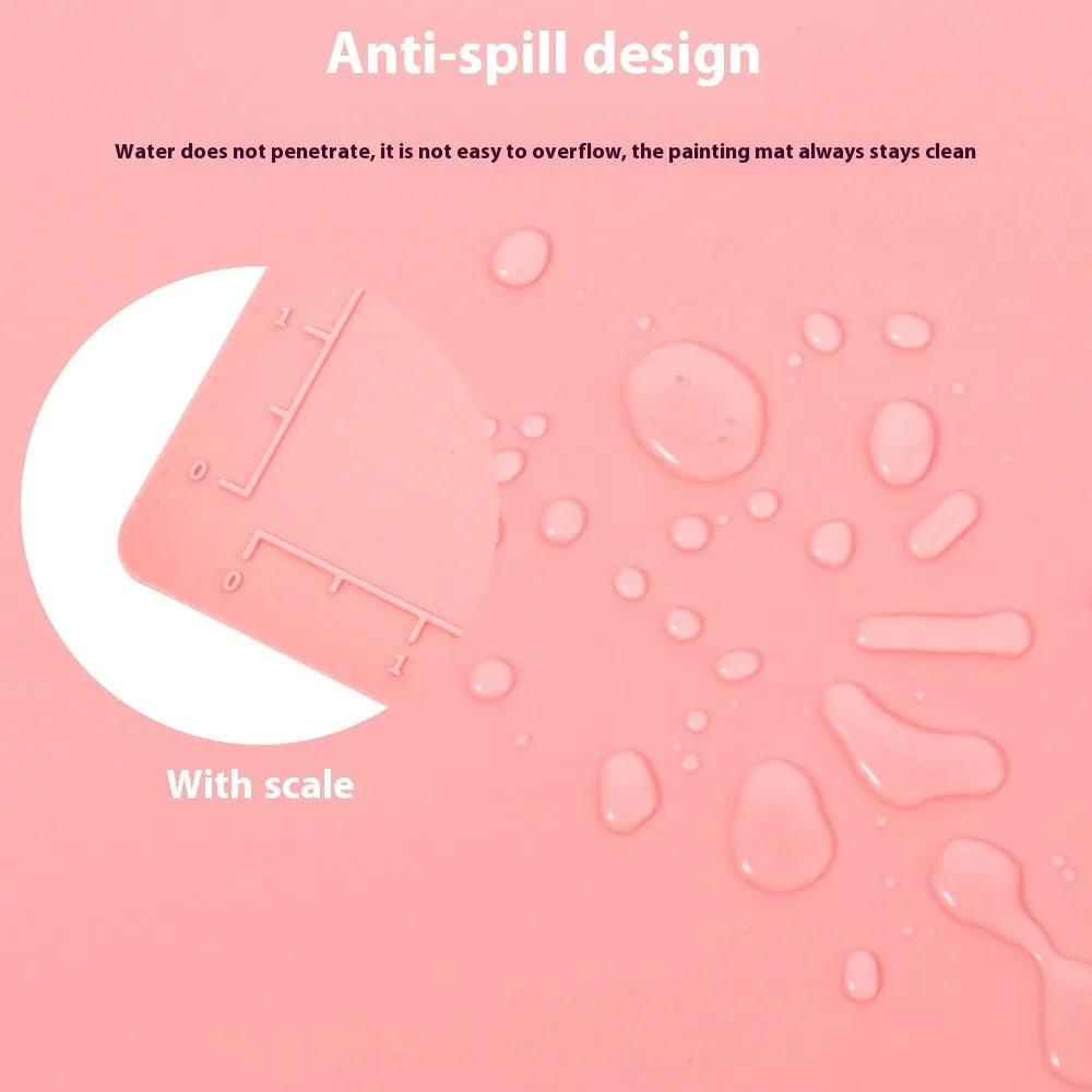 Light blue silicone painting mat with two round bowls, placed on a wooden table with paint brushes