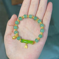 Bamboo-themed bracelet with a coloured glass flower and ruyi pattern in beige, green, light green, or white.