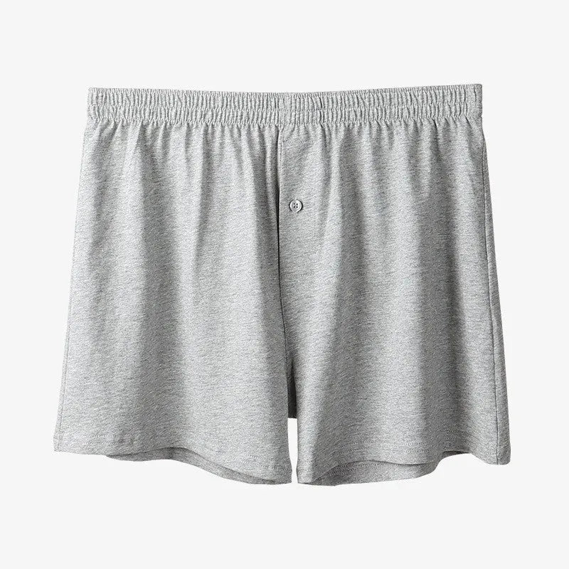 Men's solid colour cotton boxer shorts on a hanger, showing loose fit and high waist.