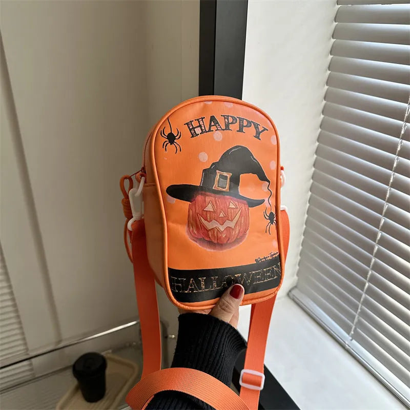 Black Halloween crossbody bag with orange pumpkin, white ghost, and black bat graffiti print, shown on adjustable strap.