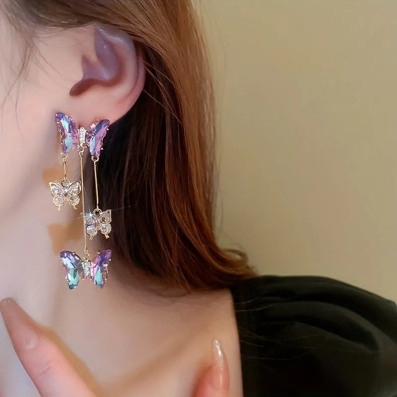 Silver needle and crystal flower earrings with blue purple butterfly tassel on alloy hooks.