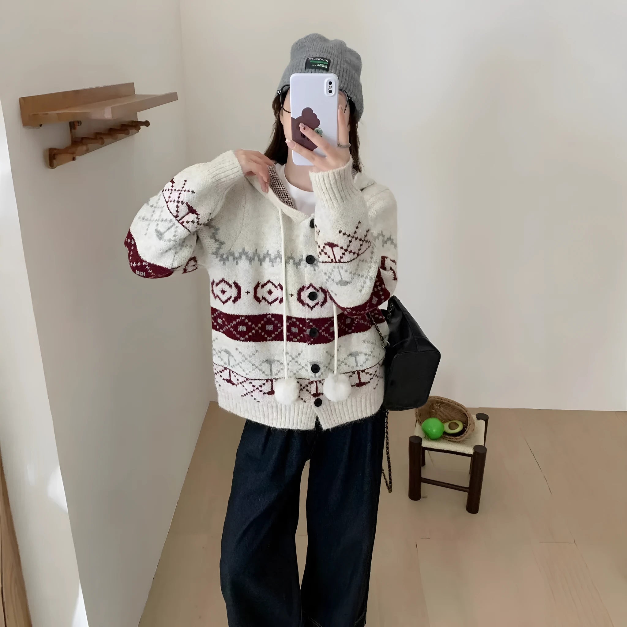 Woman wearing a beige loose-fit brocade sweater coat with a geometric pattern and long sleeves.