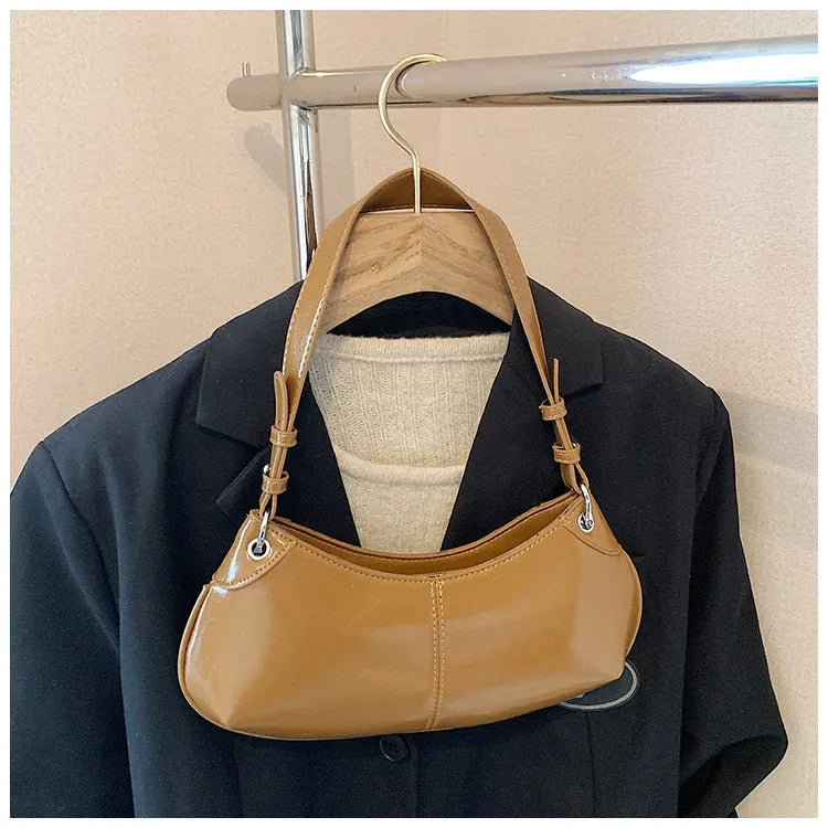 Soft PU leather dumpling shoulder bag with contrast stitching, single strap, and internal phone and file pockets.