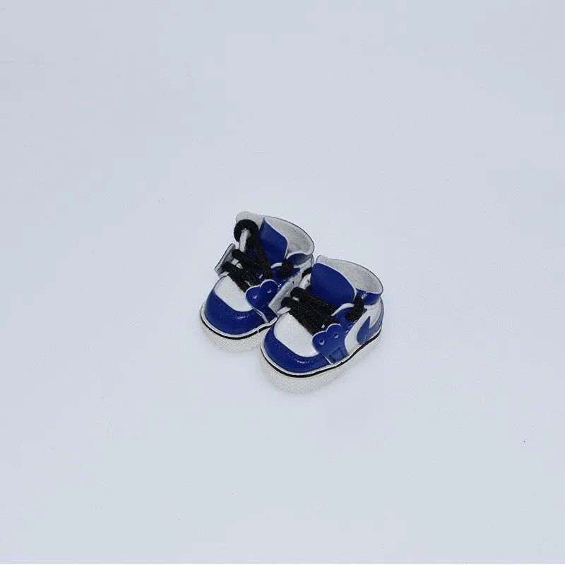 A pair of 17 cm high black doll shoes made from PU leather, shown as a keychain accessory.