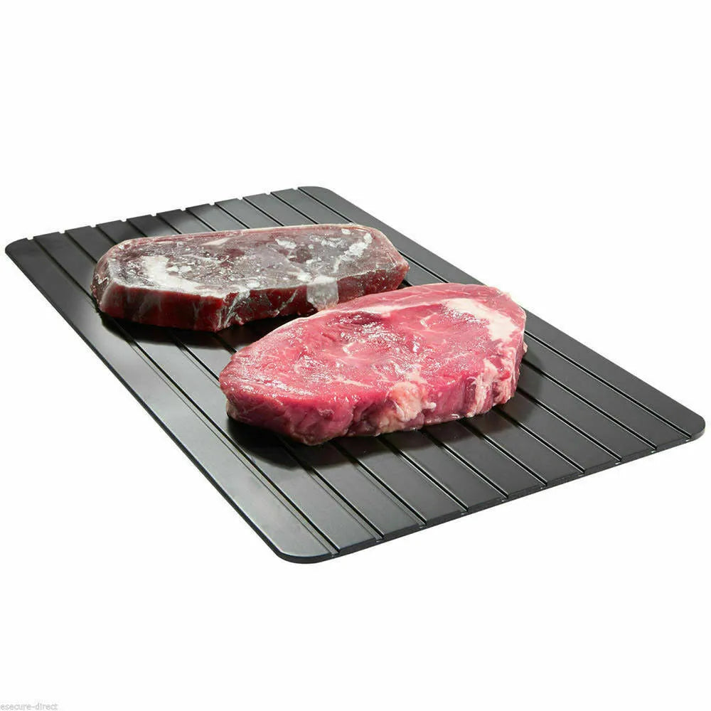 Black aluminium fast defrost tray for thawing frozen food on a kitchen counter.