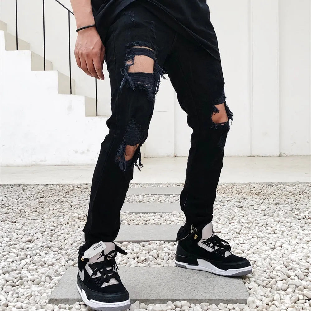 Men's black torn jeans in cotton elastic denim with raw edges, medium to low waist and zipper placket, sizes M to 2XL.