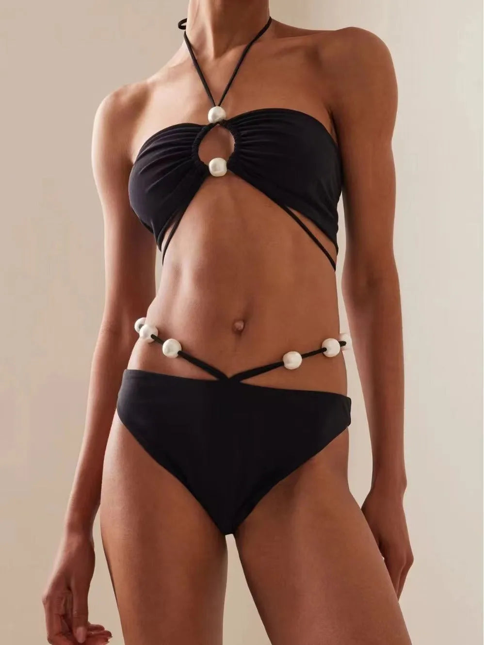 Black women's lace-up bikini swimsuit with separate bra and shorts pieces on mannequin
