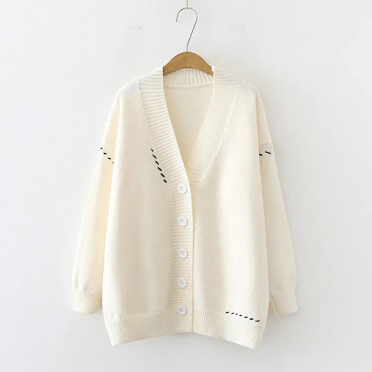 Women's loose-fit knitted cardigan coat in black or white, showing long sleeves and solid colour.