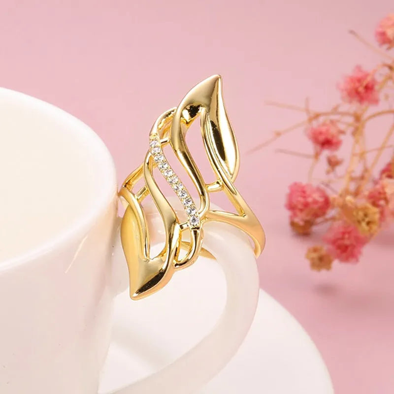 Women's exaggerated curve statement ring in gold colour with bold design on finger