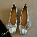 Women's silver Mary Jane loafers with flower rivets, buckle strap, round toe, and flat rubber sole.
