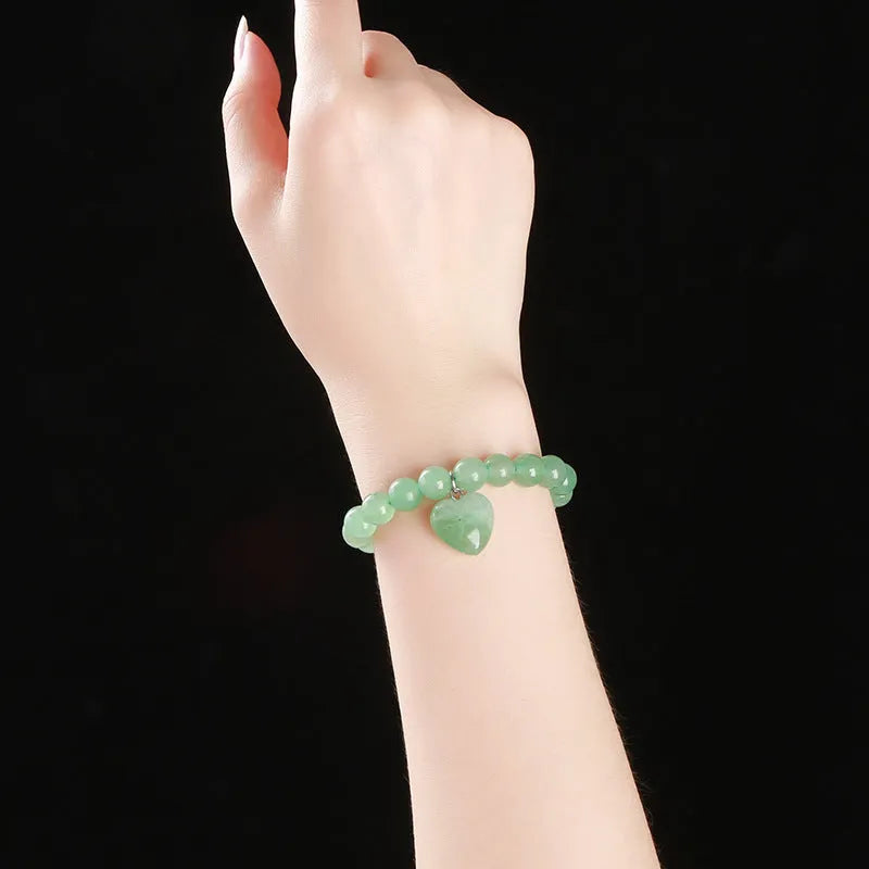 Natural crystal Tigereye love pendant bracelet with heart geometric design on woman's wrist.