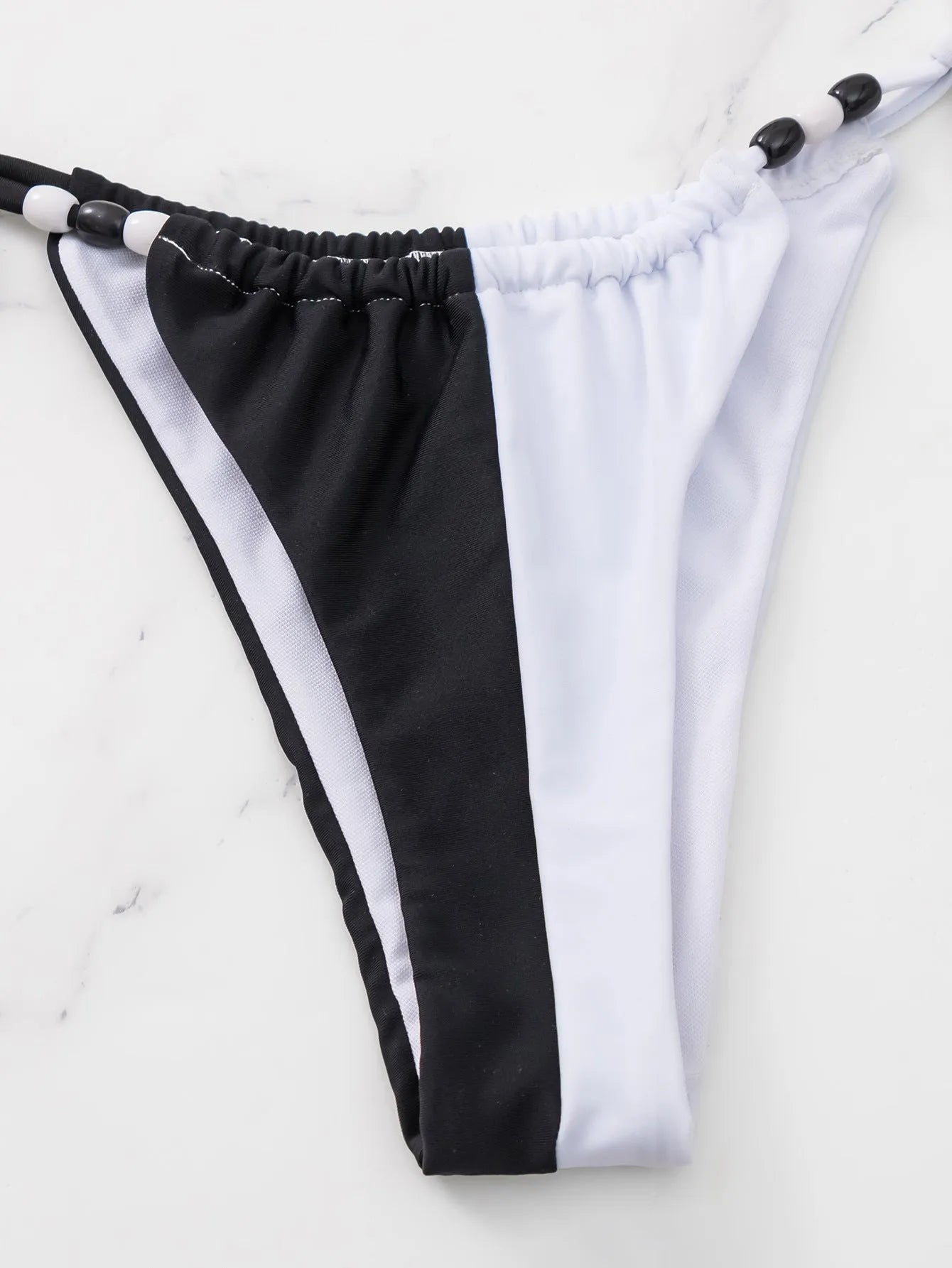 Black and white lace-up bikini swimsuit with triangle cups and adjustable tie-side bottoms