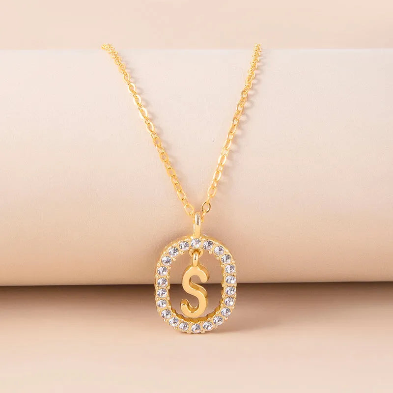 Gold crystal letter necklace with rhinestone initial on oval pendant and O-chain