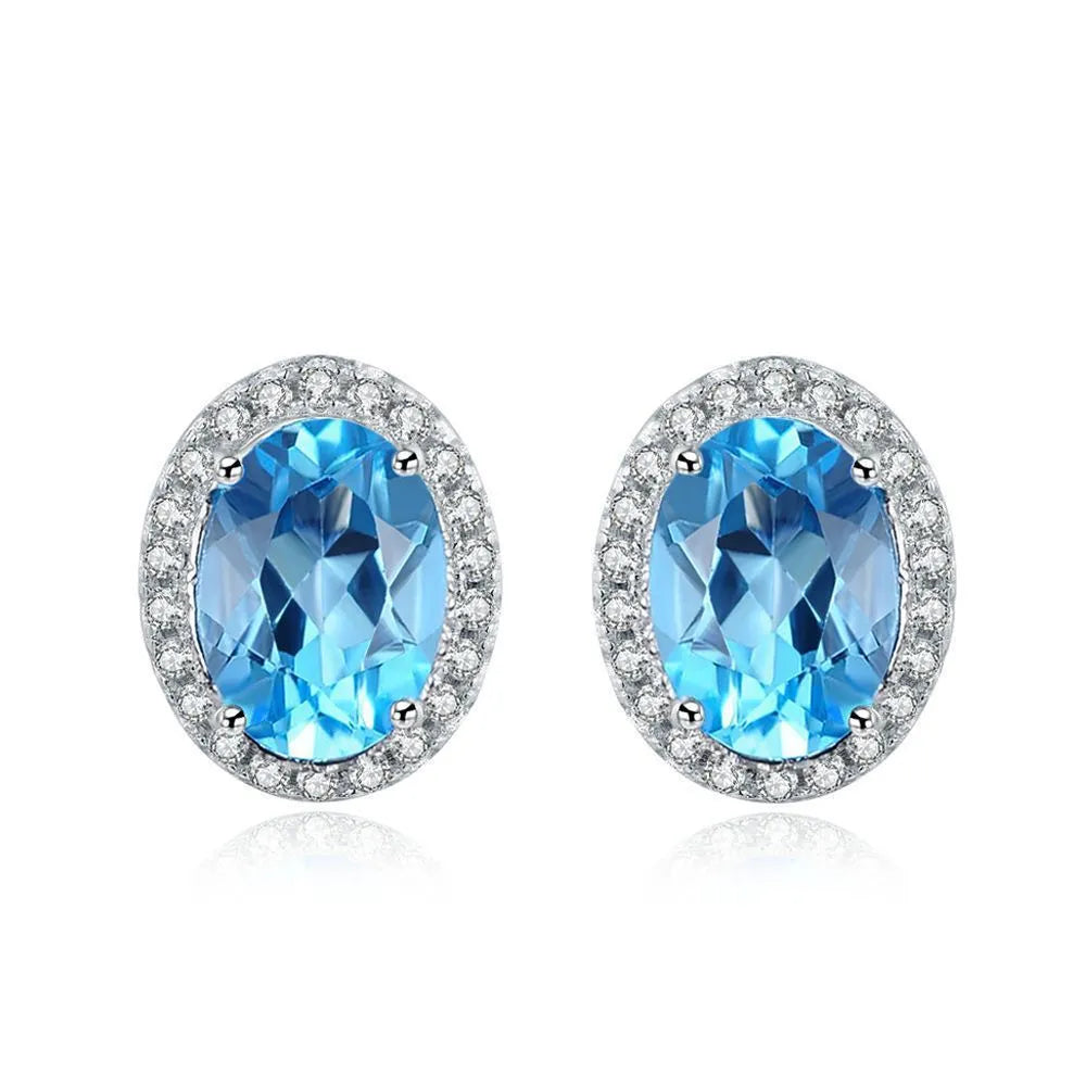 Geometric design women's sterling silver and blue topaz jewellery set showing earrings, ring, pendant, and necklace.
