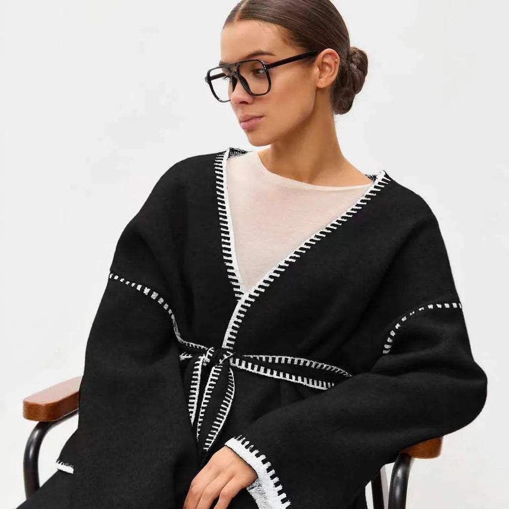 Lace-up front knitted cardigan in a camel colour, shown loose and open over a top.