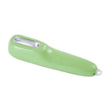 Dark green kitchen peeler with plastic handle inside its clear storage tube on a wooden surface.