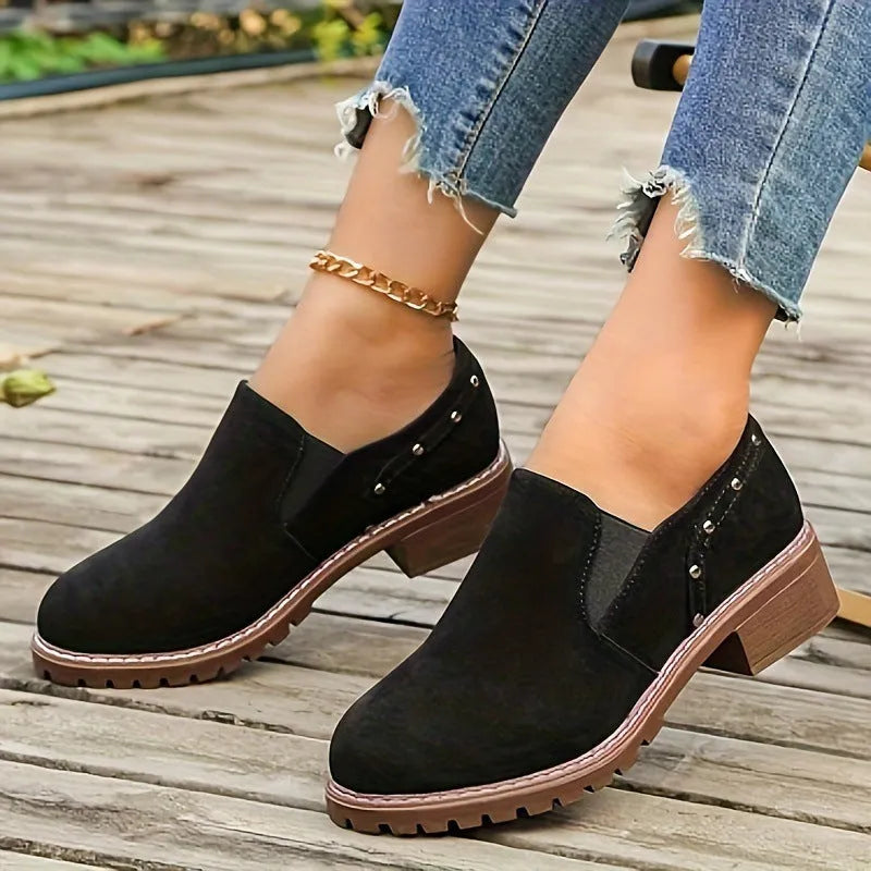 Women's light brown suede ankle boots with a low block heel and elasticated ankle cuff.