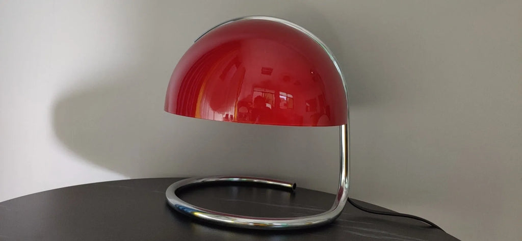 Retro metal mushroom table lamp with three-colour light in orange finish on a bedside table